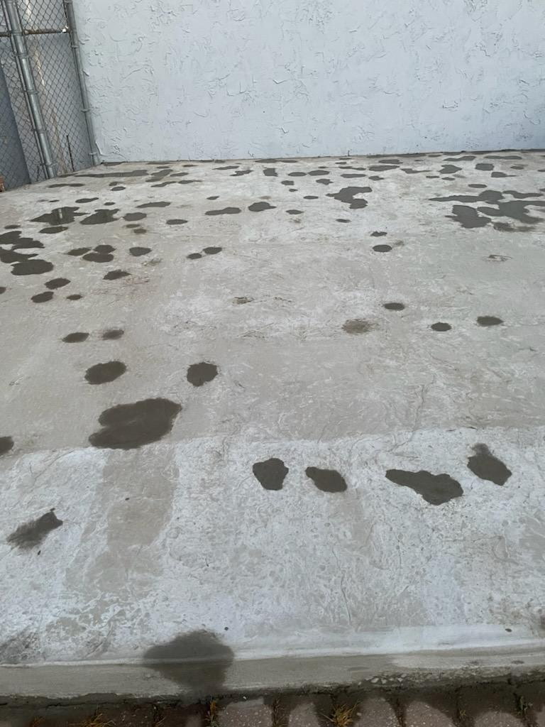 Damaged patched concrete patio before restoration
